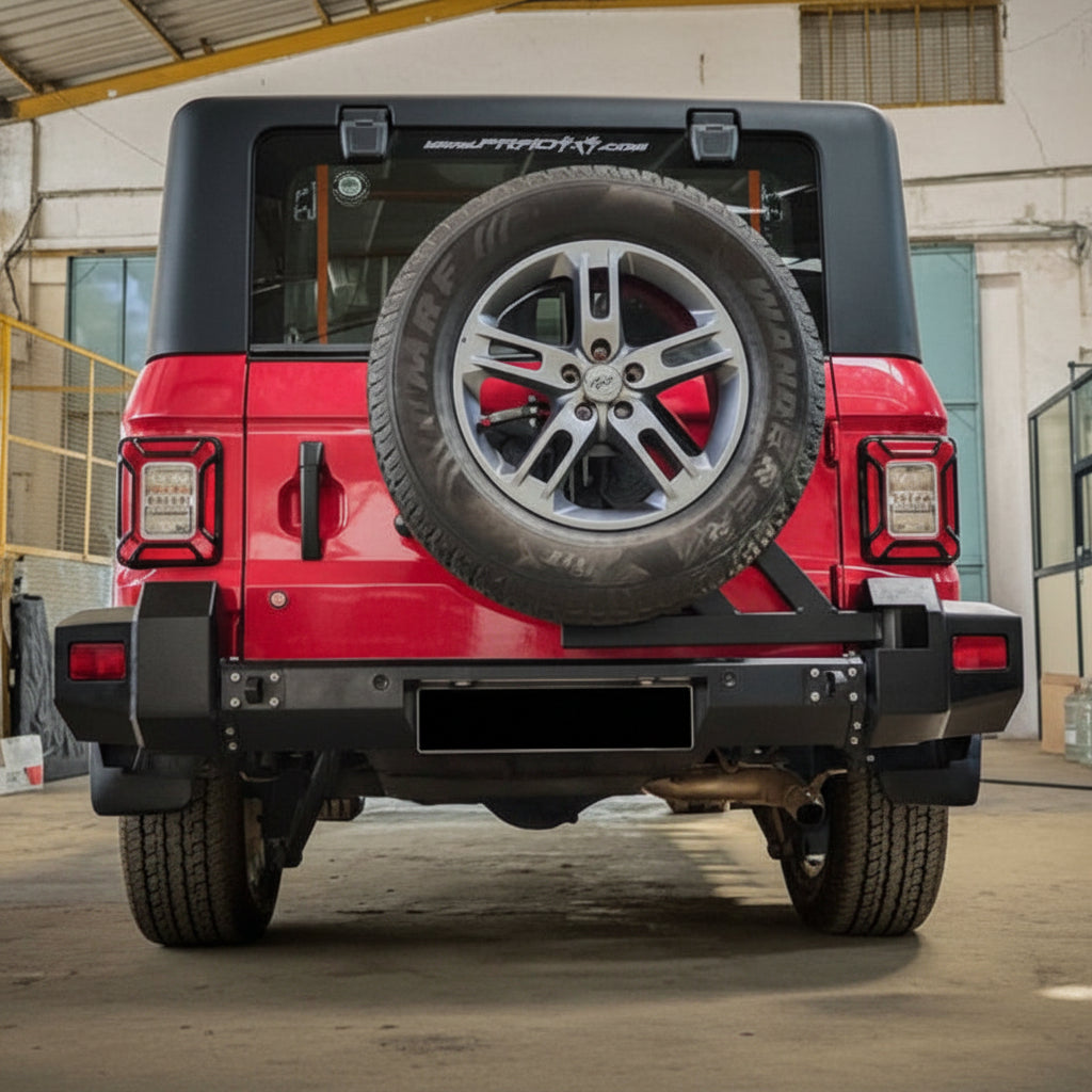 Red off-road vehicle with spare tire mounted on the back in a warehouse setting