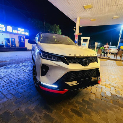 White Toyota Fortuner SUV parked at a gas station at night