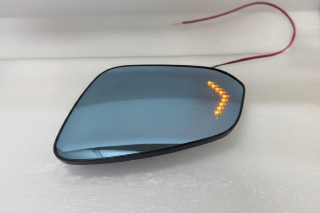 Car side mirror with turn signal indicator on a white surface