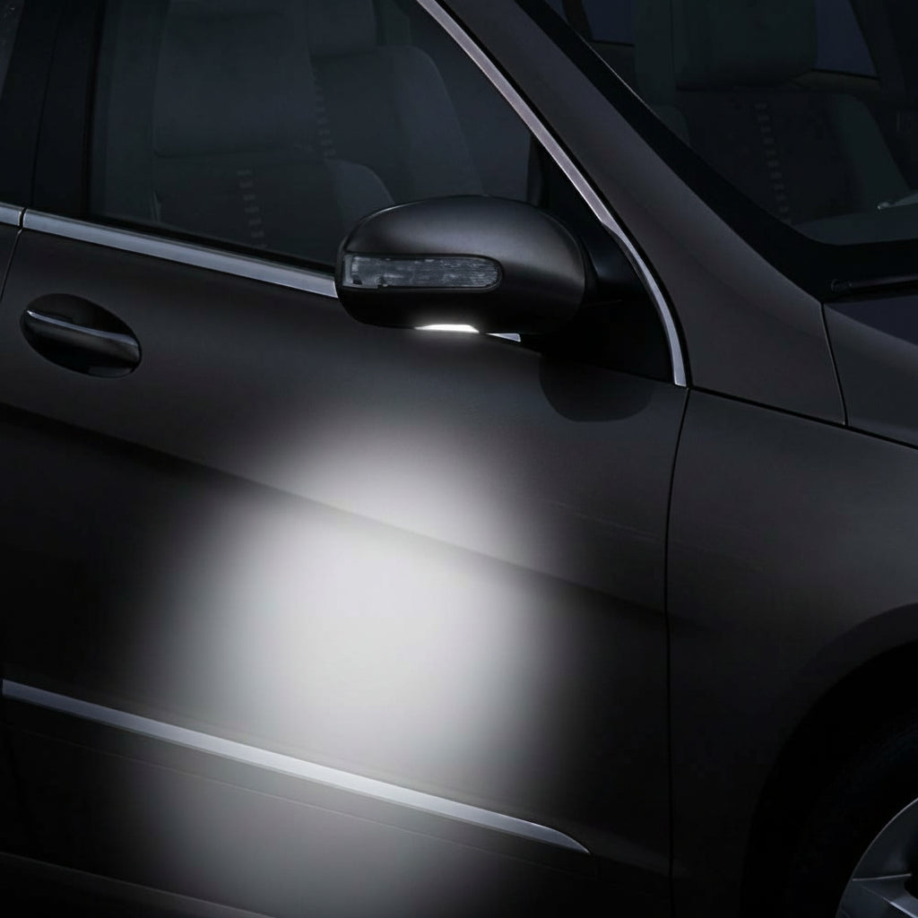 Car door with a light shining on it, highlighting the car's surface.