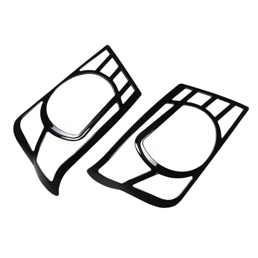 A pair of black headlight covers for Bolero 2011-2019 on a clear white background. 