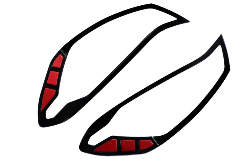 A pair of black appliqués for headlights with red reflective sections, for I20 Nios, shown on a plain white background.