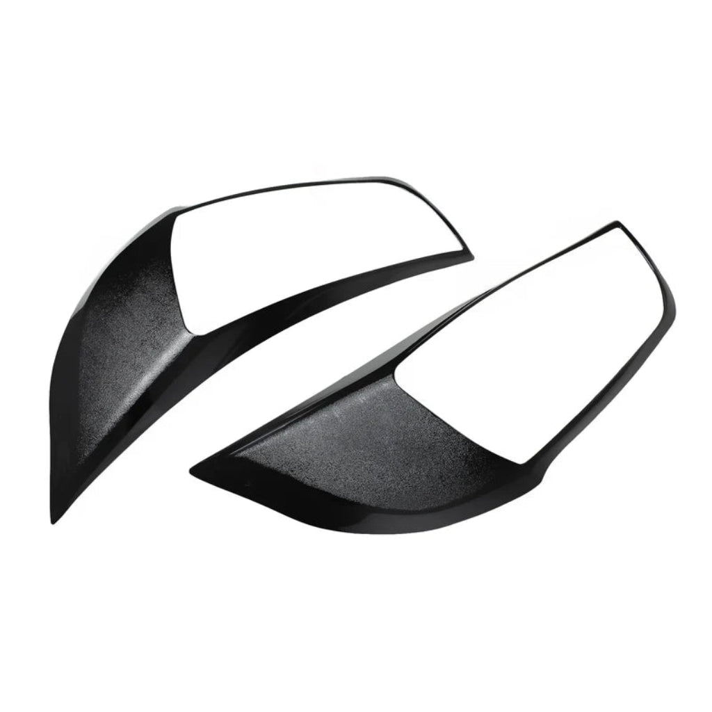 A pair of black headlight cover for alto k10 on a white background. 