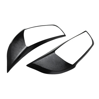 A pair of black headlight cover for alto k10 on a white background. 