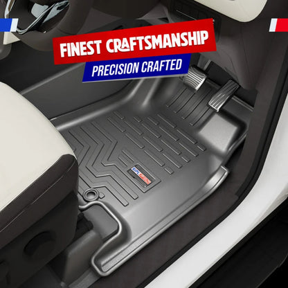 A black molded car floor mat shown installed inside a vehicle footwell, with visible pedals, seat, and door trim. Promotional text overlays read 'FINEST CRAFTSMANSHIP' and 'PRECISION CRAFTED.