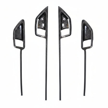 Four carbon fibre door trims on a white background