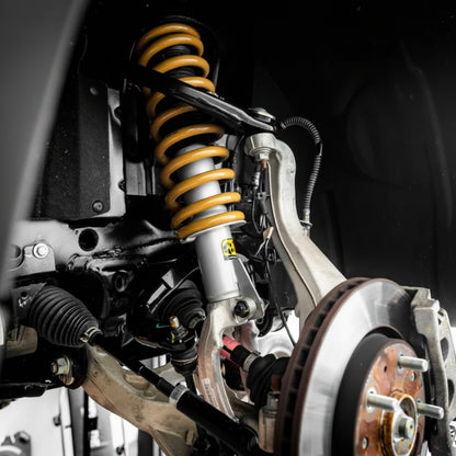 Close-up of a vehicle's suspension system with yellow shock absorber.
