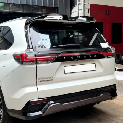 Back view of a white Toyota Innova car with visible branding.
