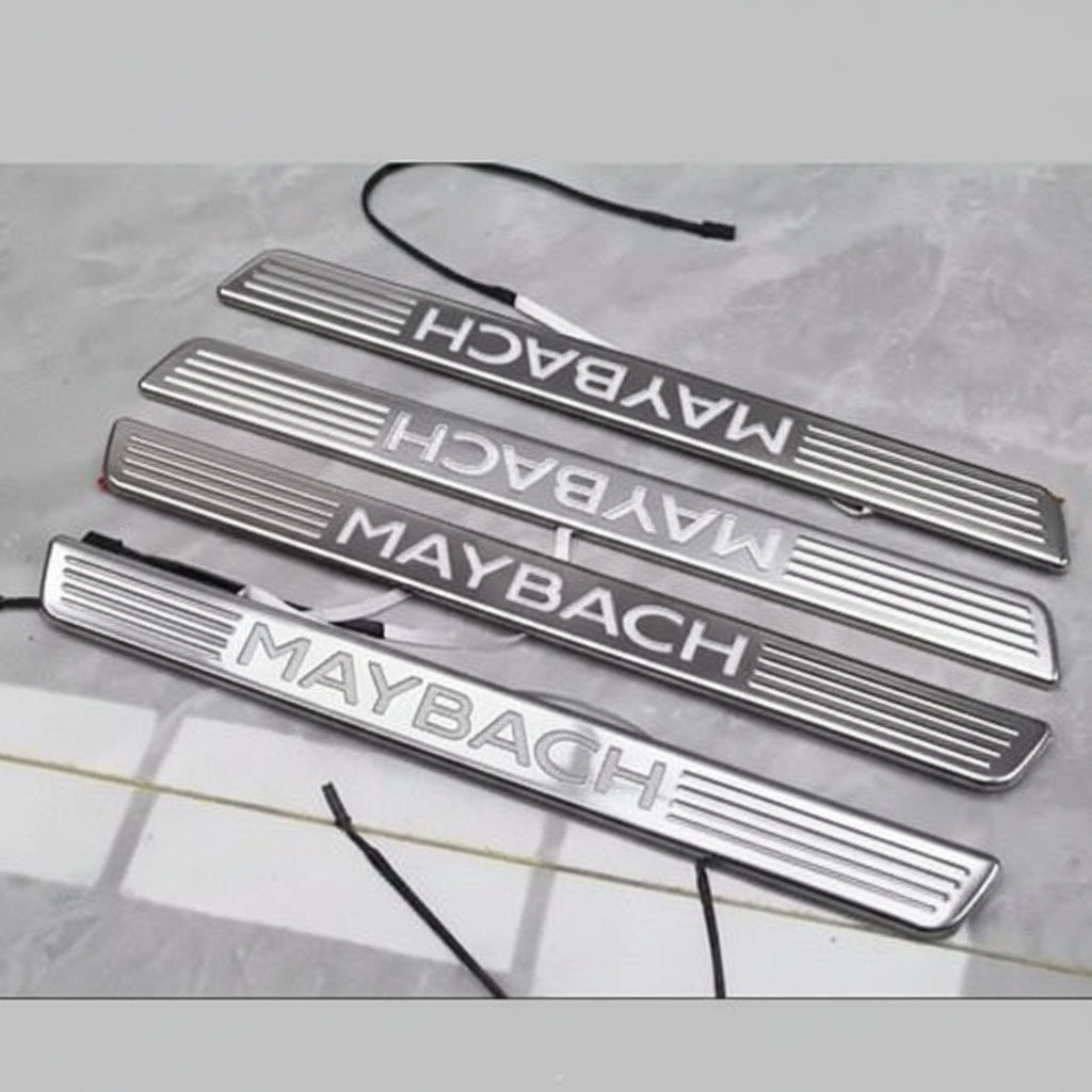 Set of Maybach branded metallic door sills on a gray surface