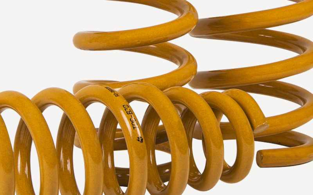 Yellow coil spring on a white background