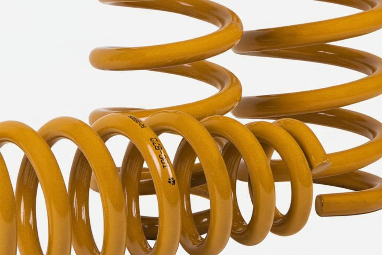 Yellow coil spring on a white background