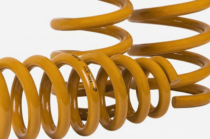 Yellow coil spring on a white background