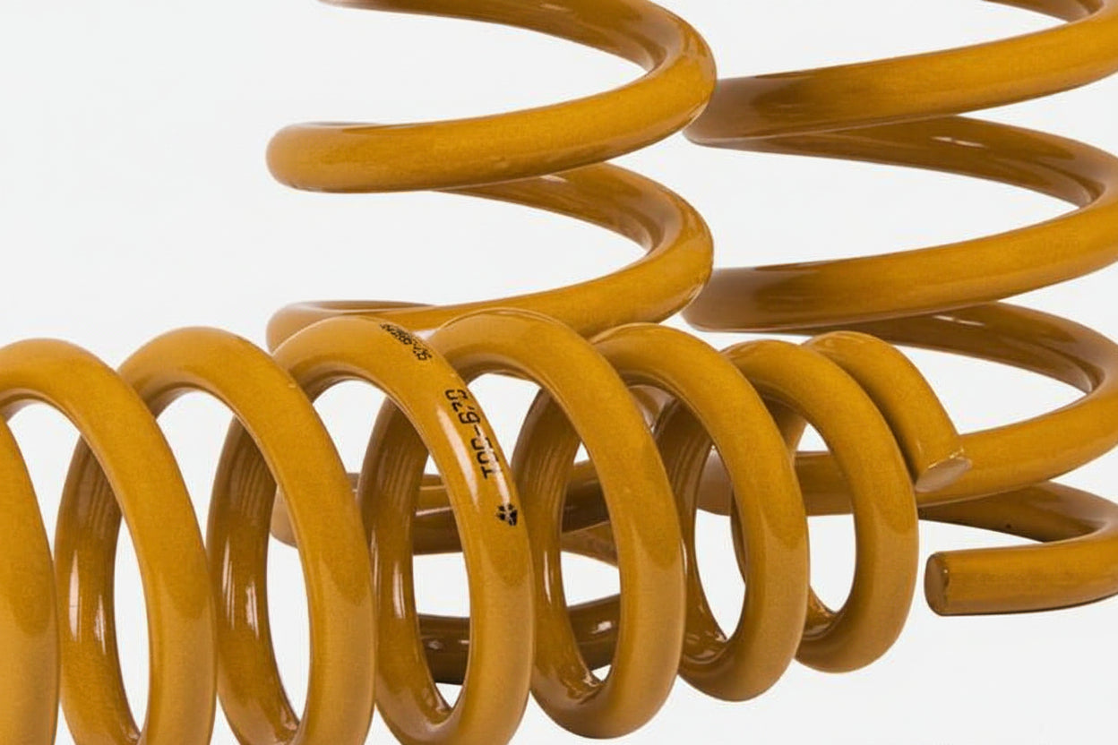Yellow coil spring on a white background