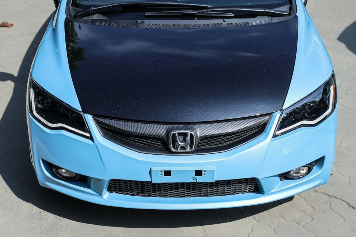 Blue Honda car with a black hood on a gray surface