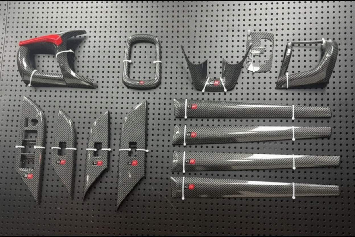 Carbon fiber car parts on a pegboard