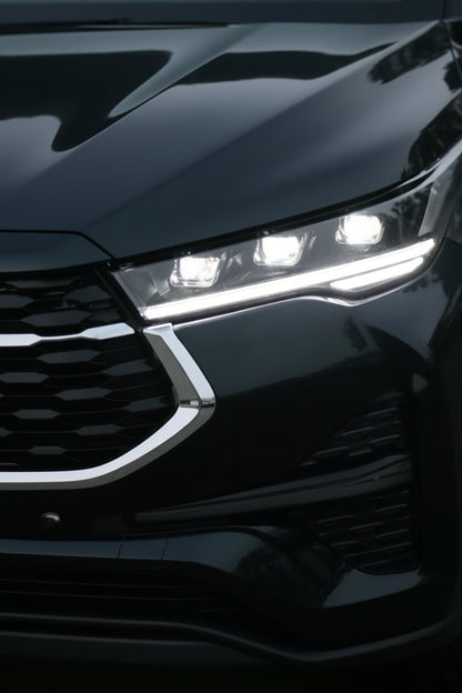 Close-up of a car's front grille and headlights with a dark background