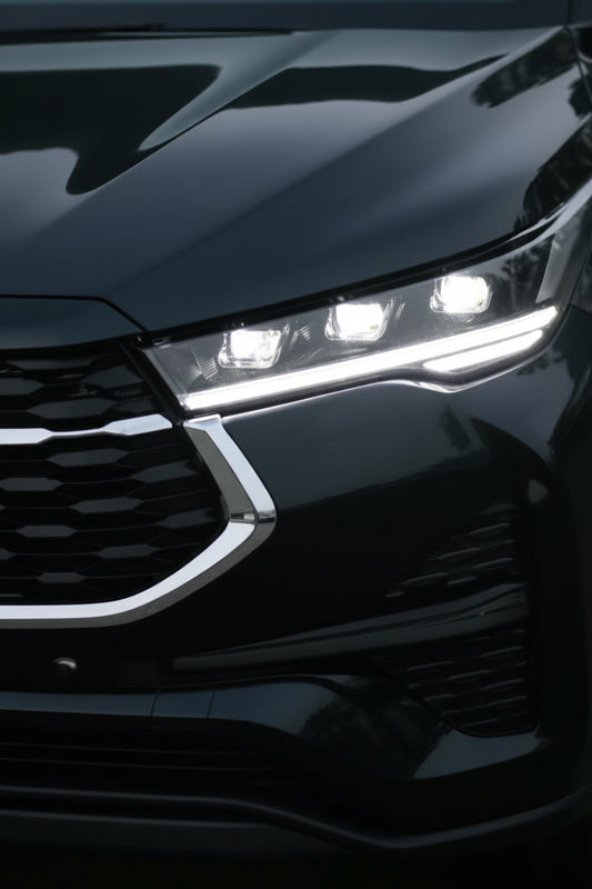 Close-up of a car's front grille and headlights with a dark background