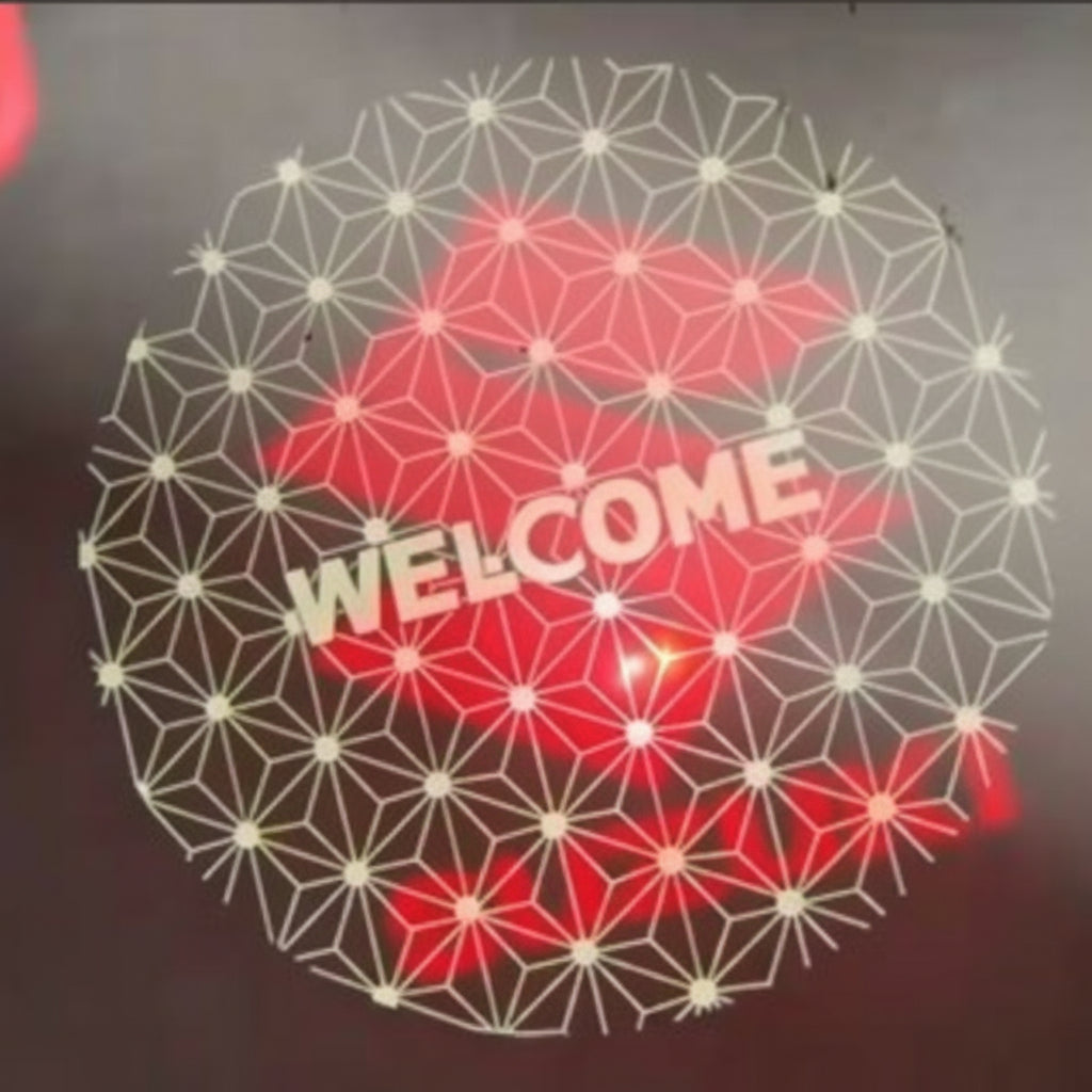 Geometric pattern projection and 'WELCOME' text on a dark background