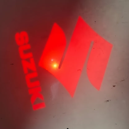 Red Suzuki logo on a dark background