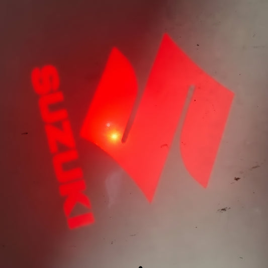 Red Suzuki logo on a dark background