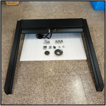 Black metal frame on a white mat with small components on a beige carpeted floor.