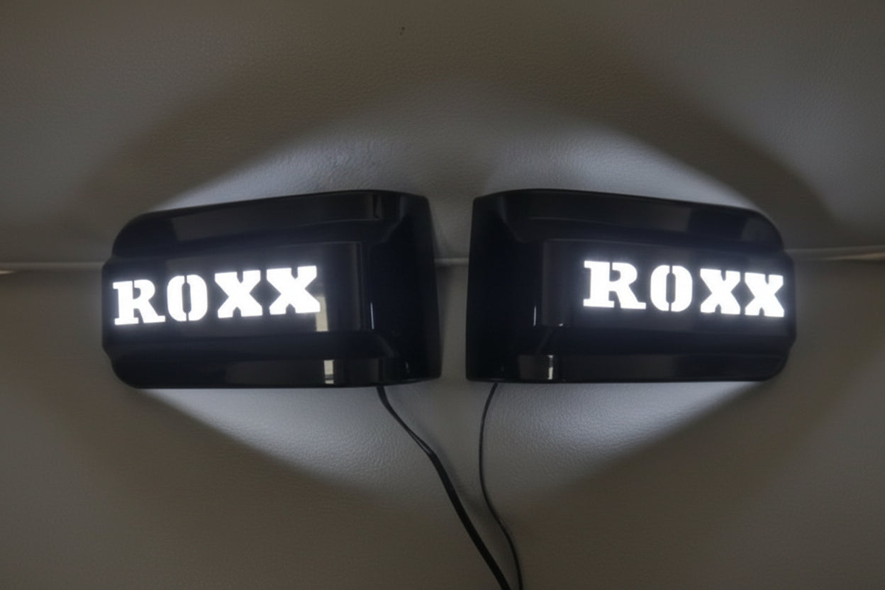 Two illuminated signs with 'ROXX' text on a plain background