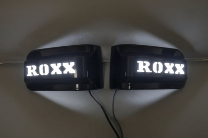 Two illuminated signs with 'ROXX' text on a plain background