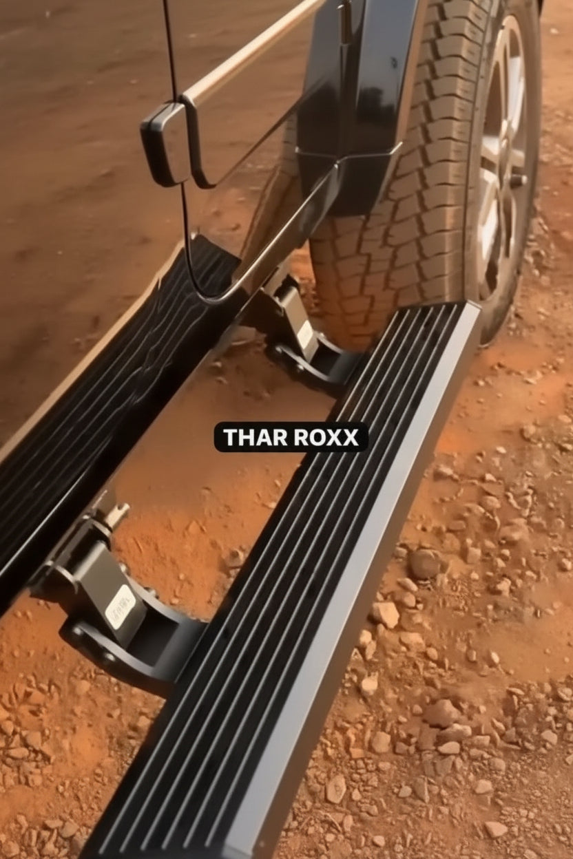 Close-up of a vehicle's step bar with 'THAR ROXX' branding on a dirt surface.