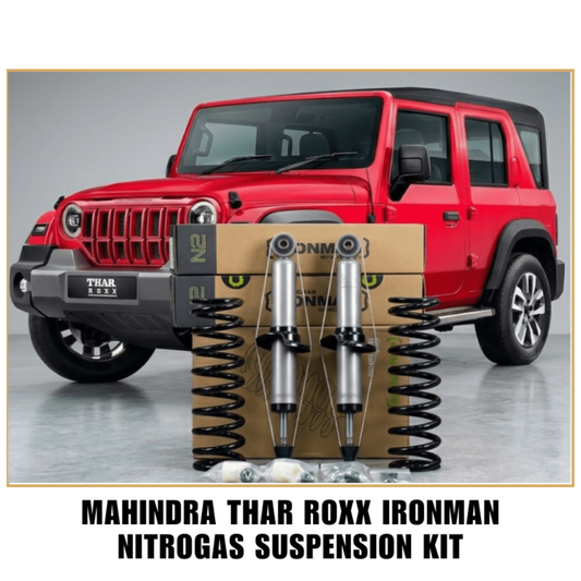 Mahindra Thar Roxx Ironman Nitrogas Suspension Kit, featuring two silver shock absorbers with black springs mounted on a cardboard box, set against a red SUV background with text overlay at the bottom.