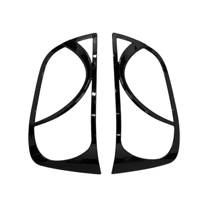 A pair of glossy black headlight covers, shown on a plain white background.