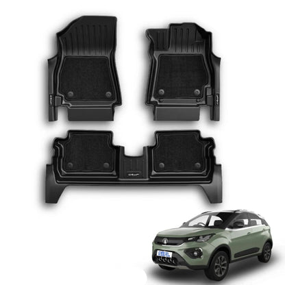 Three-piece black car floor mat set shown on a white background, with a small green car in the lower right and a blue text label reading 'NEXON (AUTO) 2023 XLMGRIP'. The product appears to be custom-fit floor mats, not the vehicle itself.